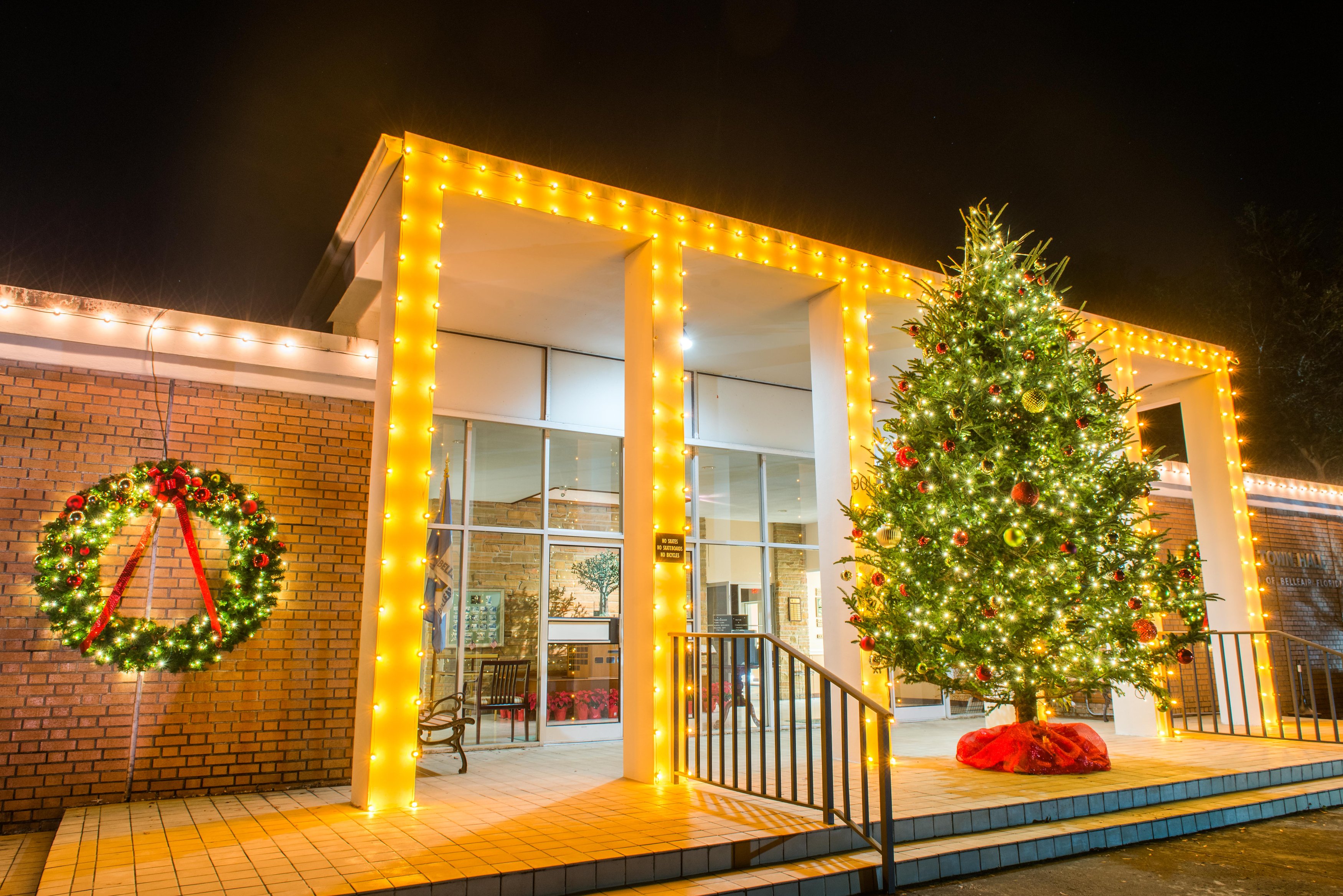 Town Hall decorated for the holiday season with white lights, wreathes, and a Christmas Tree