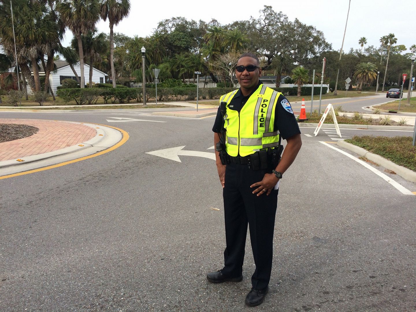 Officer Rudd stands in a street with his safety vest on for his Employee of the Month photo.