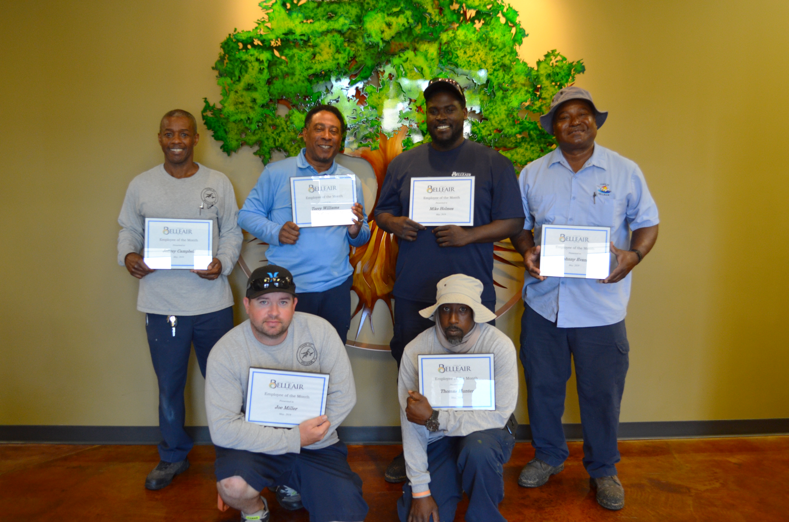 Six members of the water department smile with their employee of the month certificates for May, 201