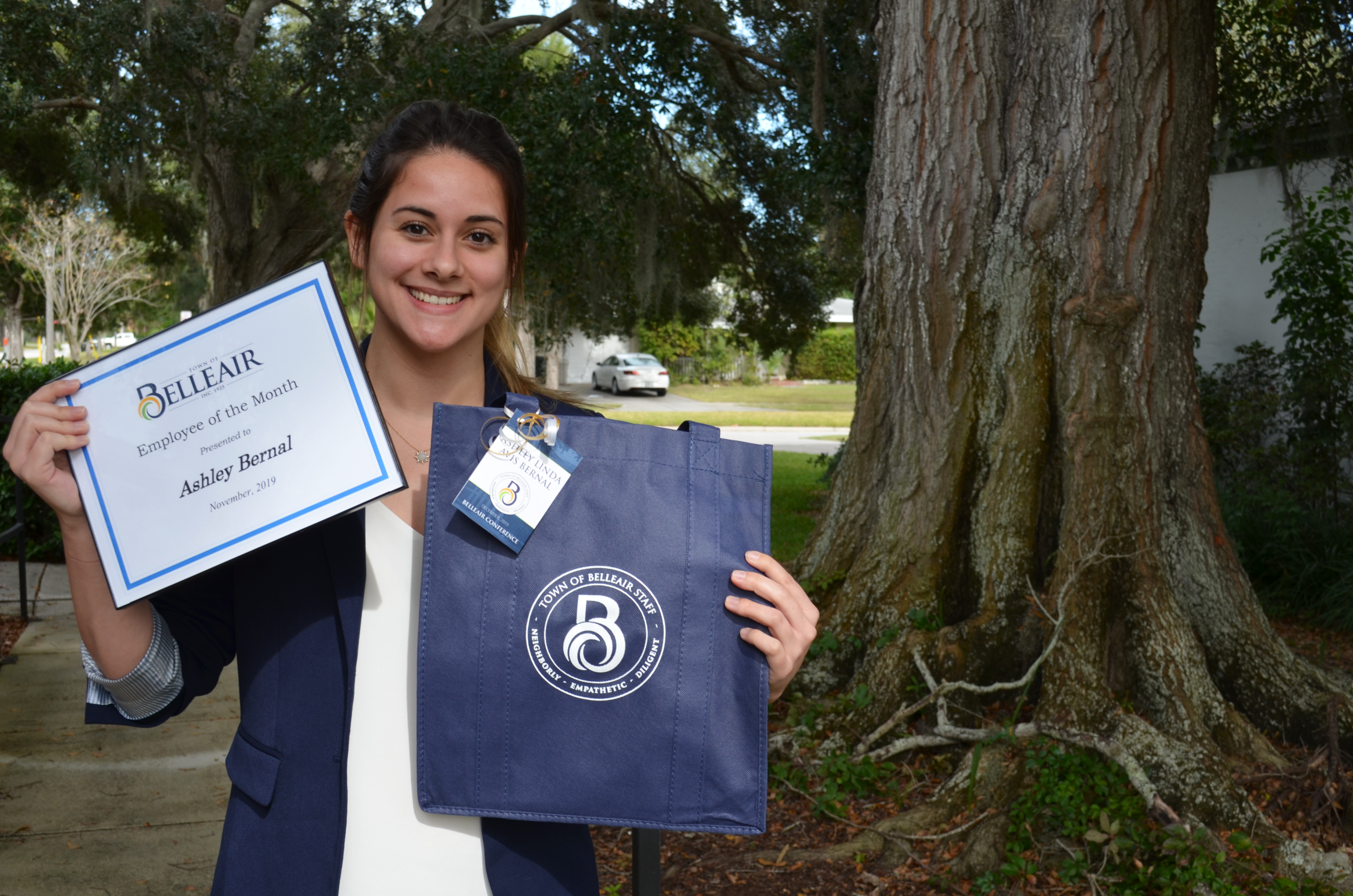 Ashley Bernal holds her Employee of the Month certificate and a branded Belleair tote she designed o