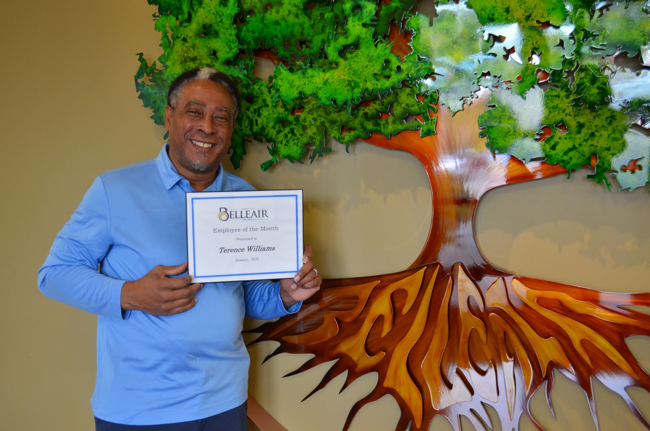Terry Williams smiles with his employee of the month certificate inside of the John J. Osborne Publi