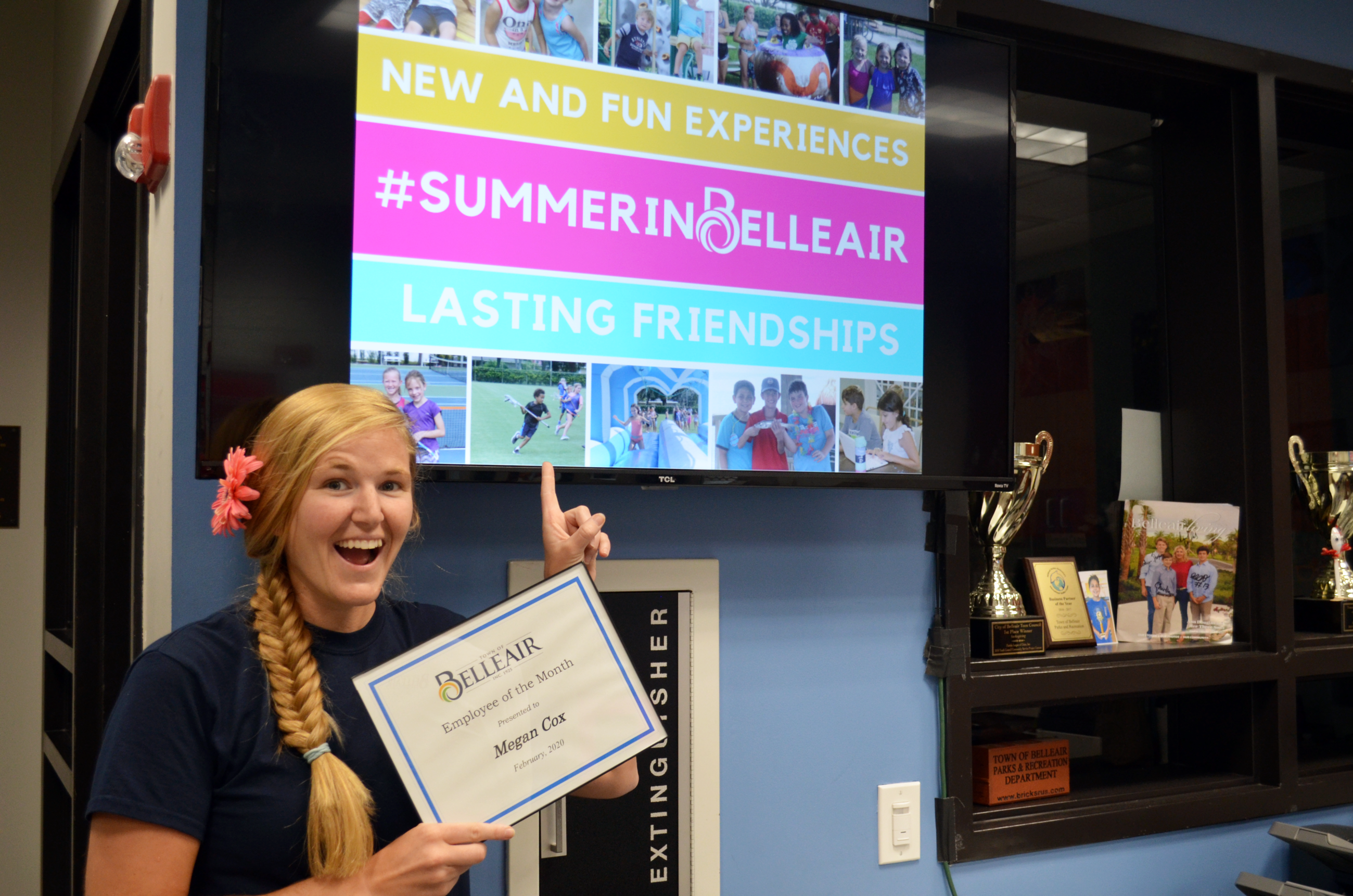 Megan from the Recreation Department poses with her employee of the month certificate in front of an