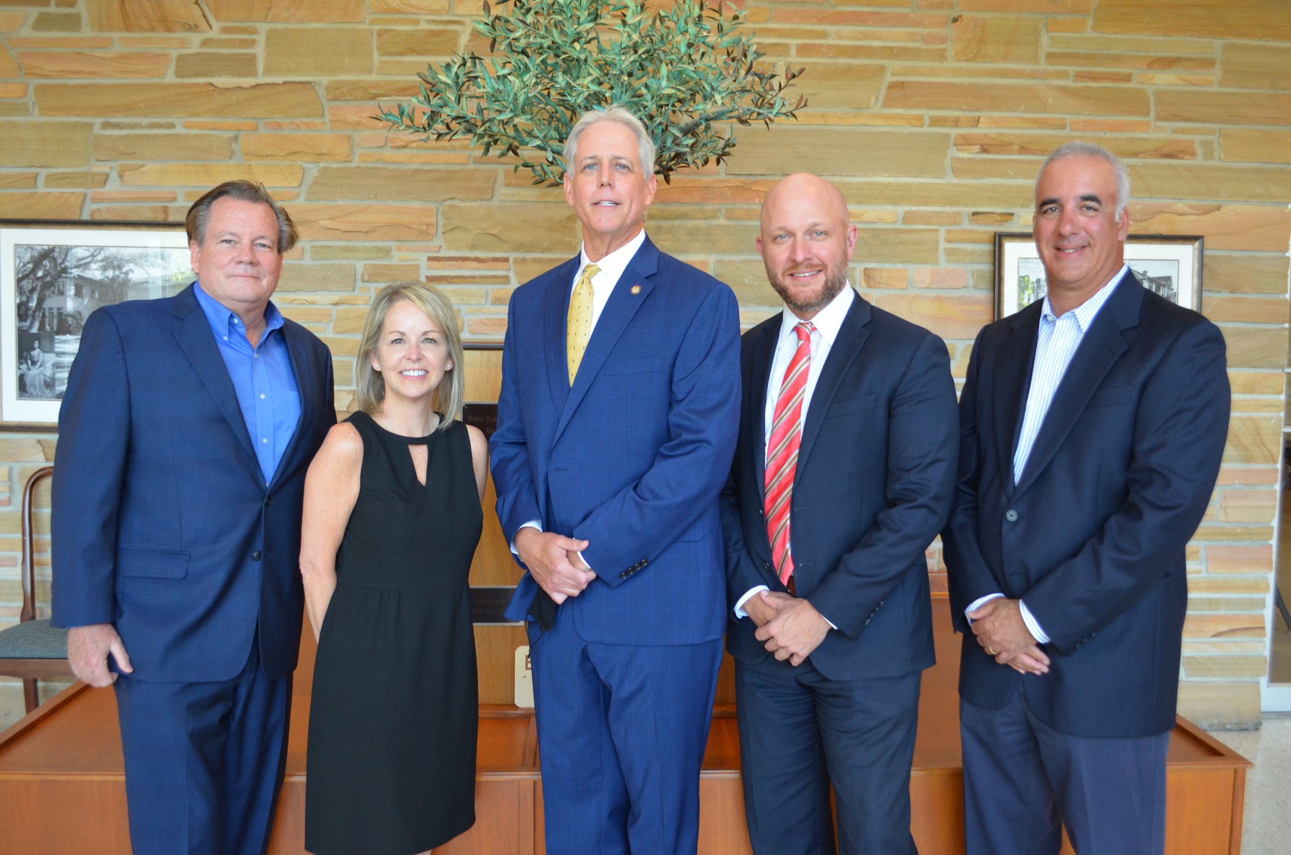 The Town of Belleair Commission (mayor and four commissioners) in smiling in the Town Hall lobby.