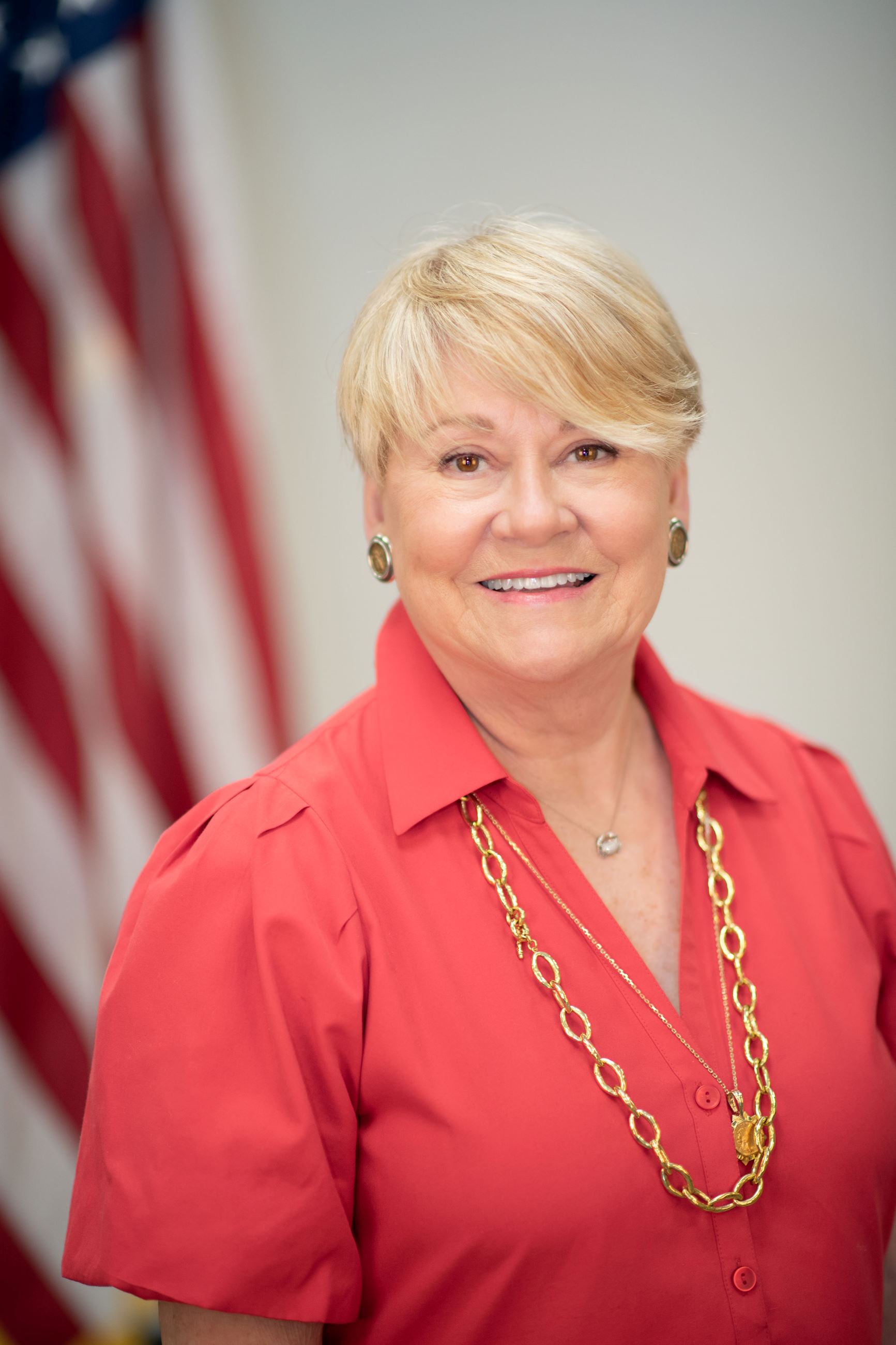 Belleair Town Manager, Gay Lancaster, poses with a smile in front of the American flag.